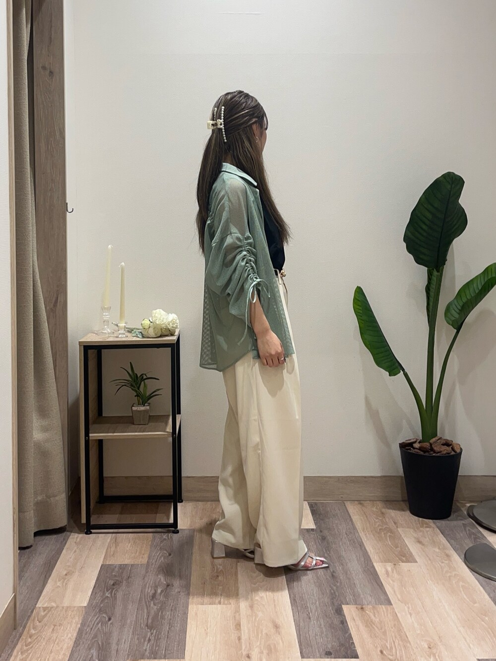 グリーン系のシャツ/ブラウス、ホワイト系のスラックス、ブラック系のベルトを着用したレディースの夏コーディネートの2枚目の写真