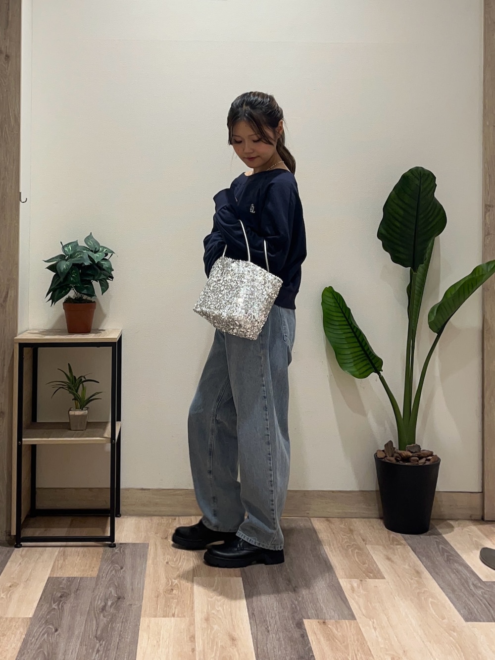 ブルー系のデニムパンツ、ブルー系のTシャツ/カットソー、ブラック系のブーツを着用したレディースの秋コーディネートの5枚目の写真