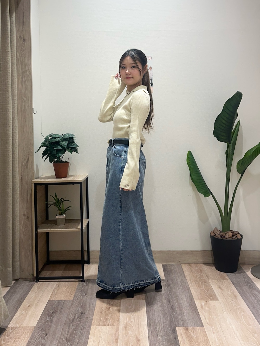 ブルー系のスカート、ホワイト系のニット/セーター、ブラック系のベルトを着用したレディースの秋コーディネートの5枚目の写真