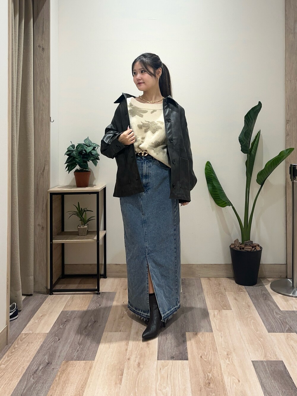 ホワイト系のニット/セーター、ブラック系のブルゾン、ブルー系のスカートを着用したレディースの秋コーディネートの2枚目の写真