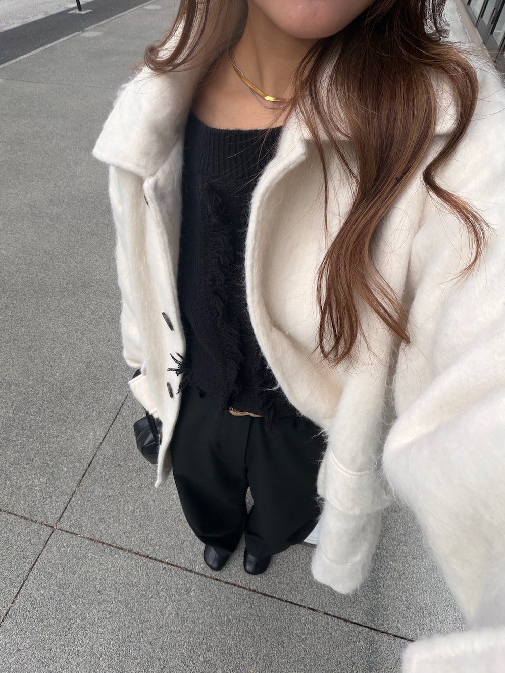 ホワイト系のその他アウター、ブラック系のニット/セーター、ブラック系のブーツを着用したレディースの冬コーディネートの5枚目の写真