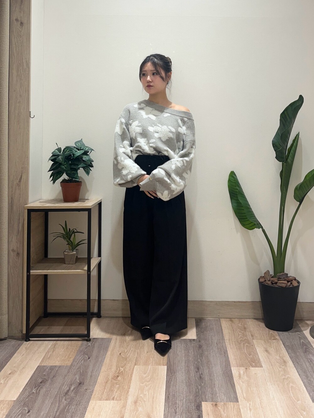 ブラック系のスラックス、グレー系のニット/セーター、ブラック系のパンプスを着用したレディースの秋コーディネートの2枚目の写真