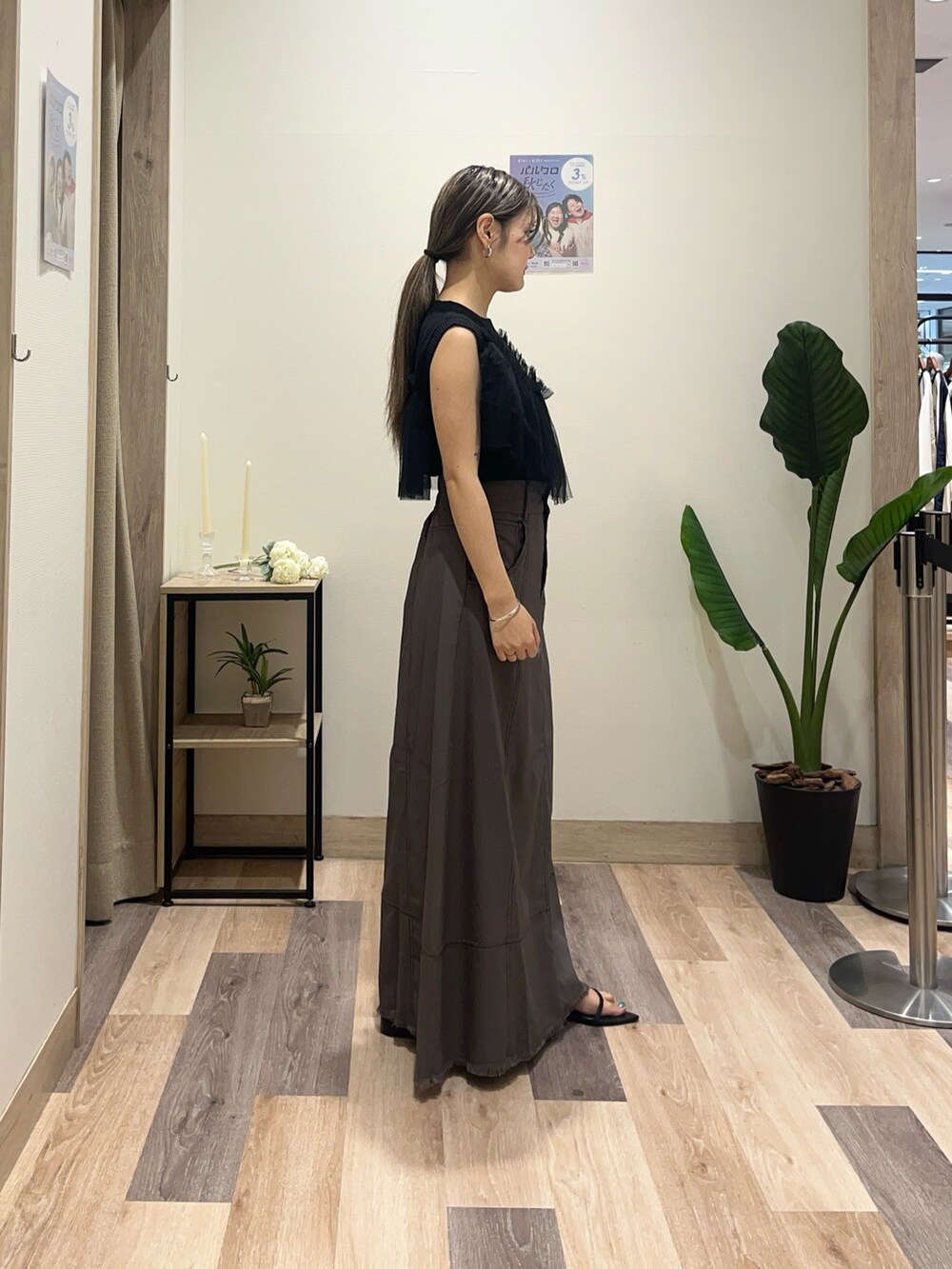 グレー系のスカート、ブラック系のニット/セーターを着用したレディースの夏コーディネートの2枚目の写真