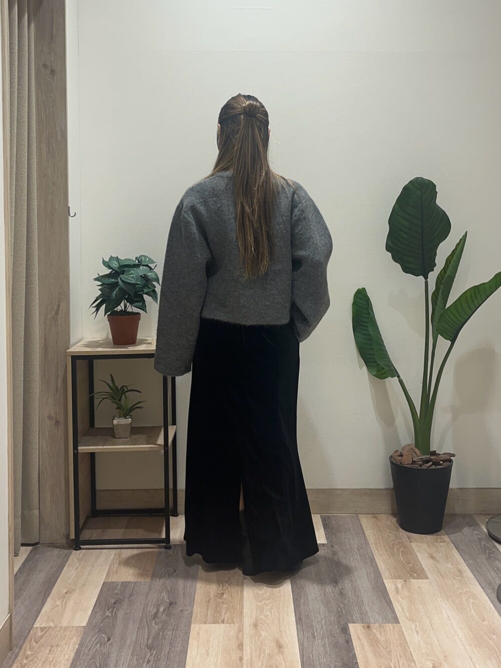 ブラック系のスカート、ブラック系のブーツ、グレー系のブルゾンを着用したレディースの冬コーディネートの4枚目の写真