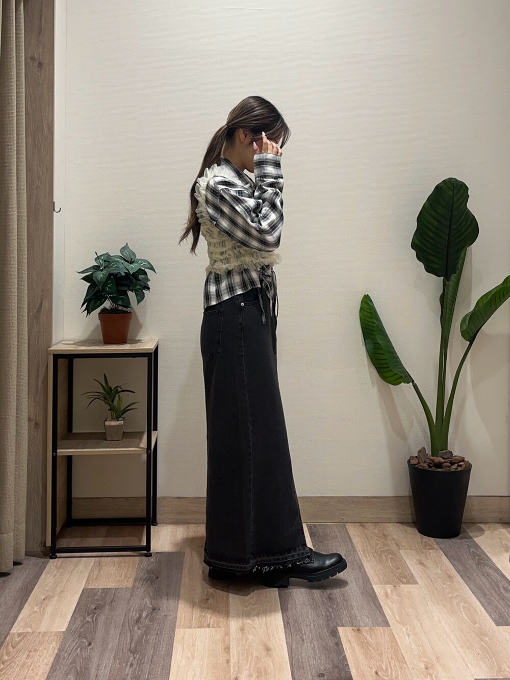 ブラック系のスカート、ブラック系のシャツ/ブラウス、ブラック系のブーツを着用したレディースの秋コーディネートの3枚目の写真