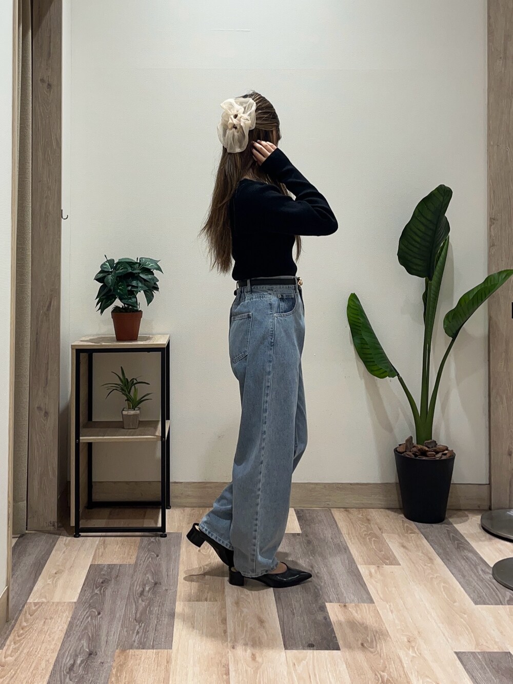 ブルー系のデニムパンツ、ブラック系のニット/セーター、ブラック系のベルトを着用したレディースの秋コーディネートの2枚目の写真