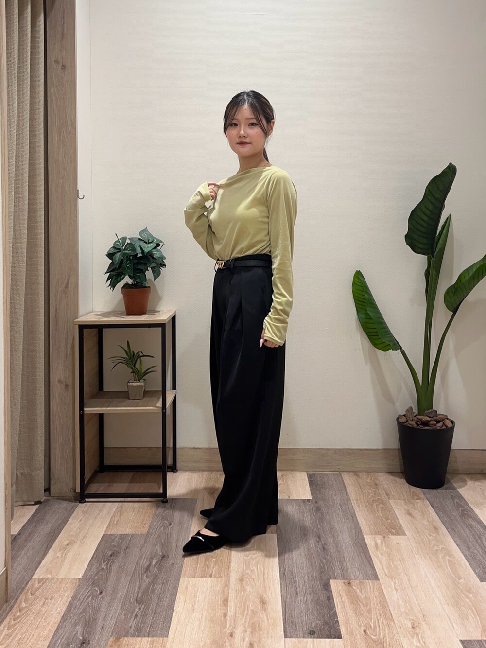 グリーン系のTシャツ/カットソー、ブラック系のスラックス、ブラック系のパンプスを着用したレディースの秋コーディネートの5枚目の写真