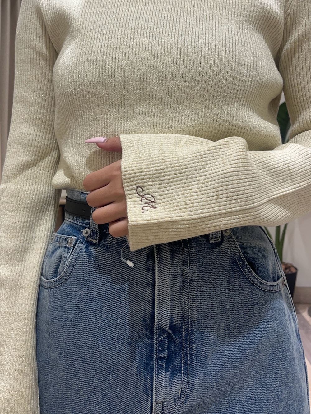 ブルー系のスカート、ホワイト系のニット/セーター、ブラック系のベルトを着用したレディースの秋コーディネートの6枚目の写真