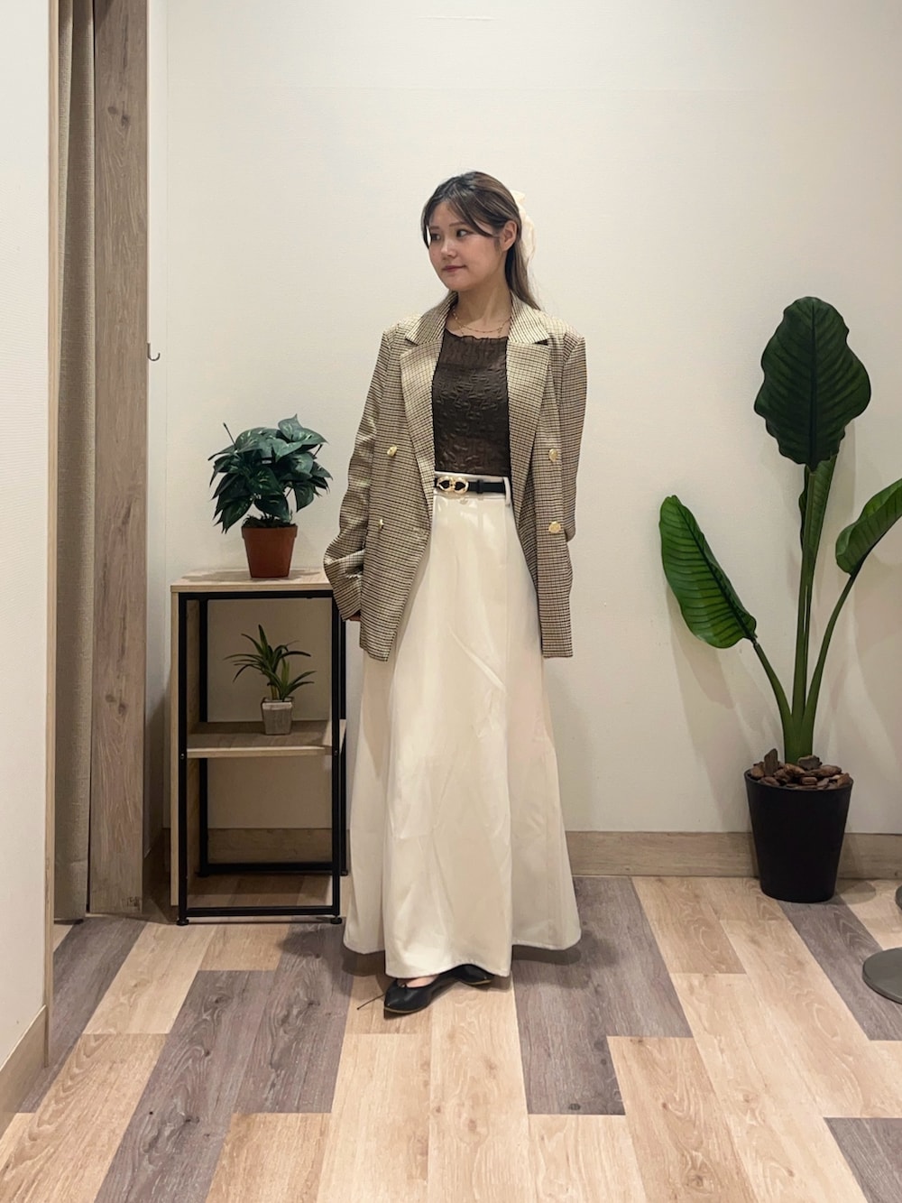 ホワイト系のスカート、ベージュ系のテーラードジャケット、ブラウン系のTシャツ/カットソーを着用したレディースの秋コーディネートの2枚目の写真
