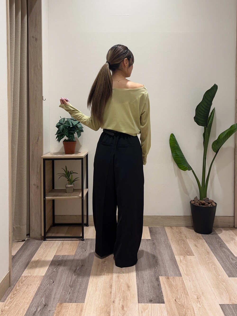 グリーン系のTシャツ/カットソー、ブラック系のスラックス、ブラック系のパンプスを着用したレディースの秋コーディネートの4枚目の写真