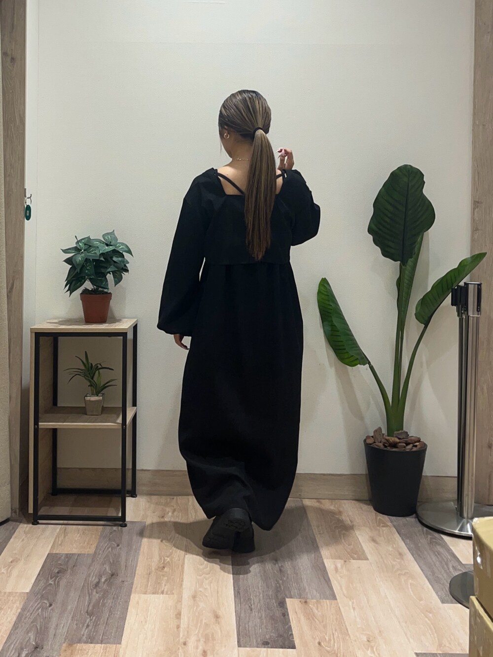 ブラック系のワンピース、ブラック系のブーツを着用したレディースの秋コーディネートの4枚目の写真