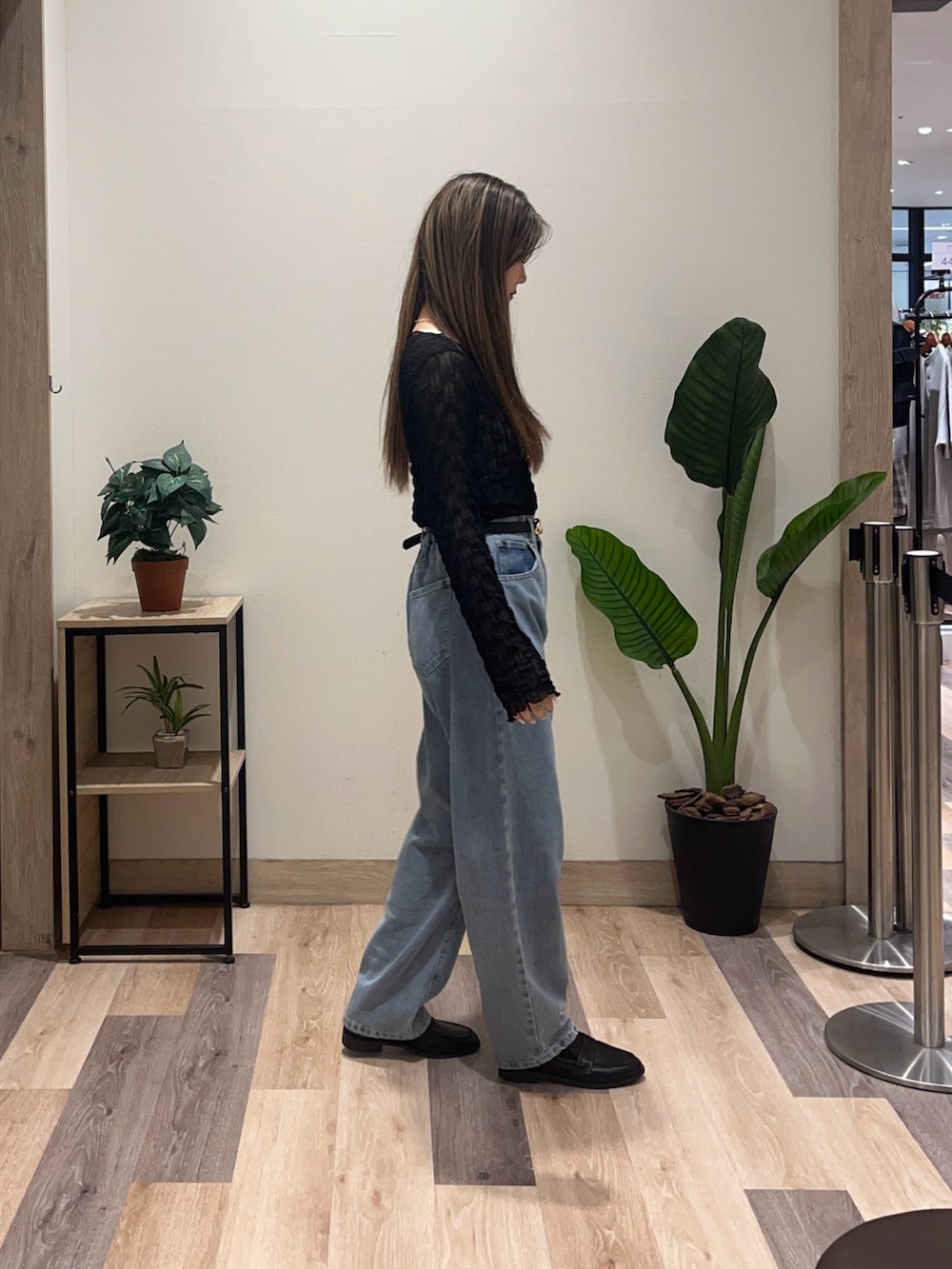 ブルー系のデニムパンツ、ブラック系のTシャツ/カットソー、ブラック系のベルトを着用したレディースの秋コーディネートの3枚目の写真