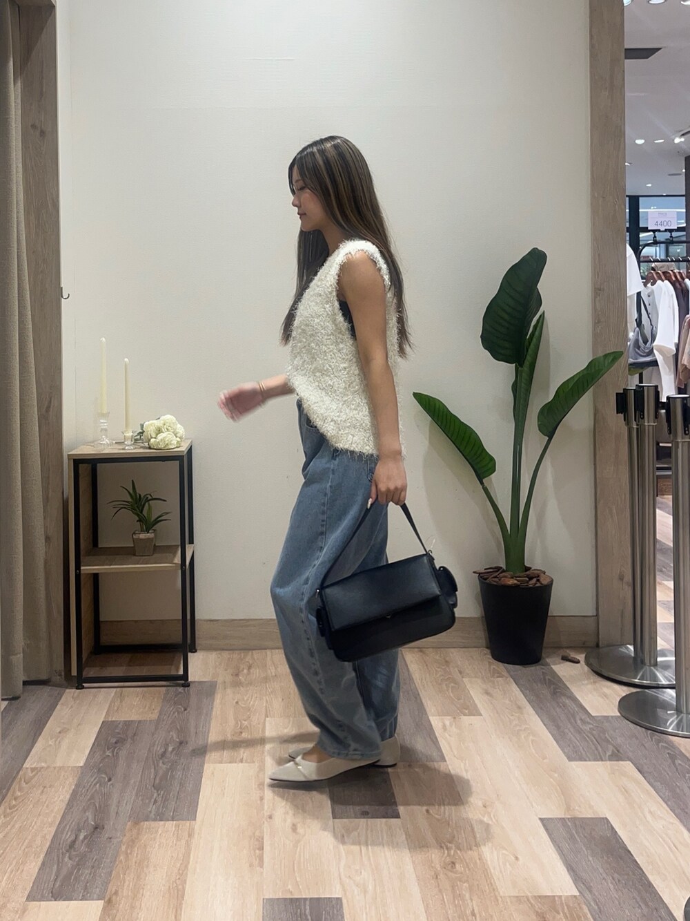 ホワイト系のニット/セーター、ブルー系のデニムパンツ、ブラック系のボストンバッグを着用したレディースの秋コーディネートの3枚目の写真