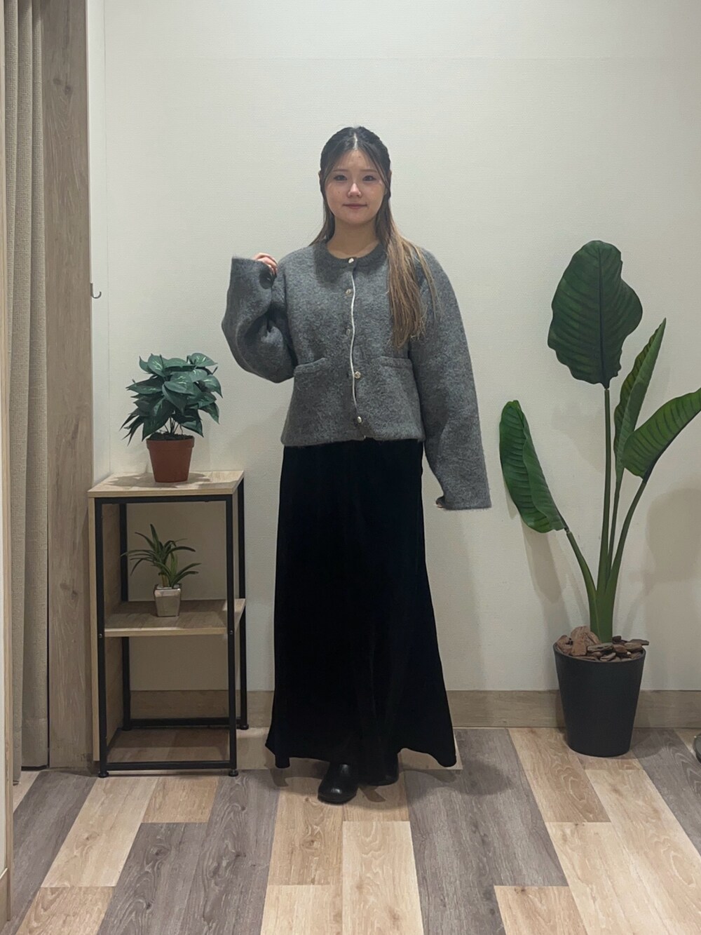 ブラック系のスカート、ブラック系のブーツ、グレー系のブルゾンを着用したレディースの冬コーディネートの2枚目の写真