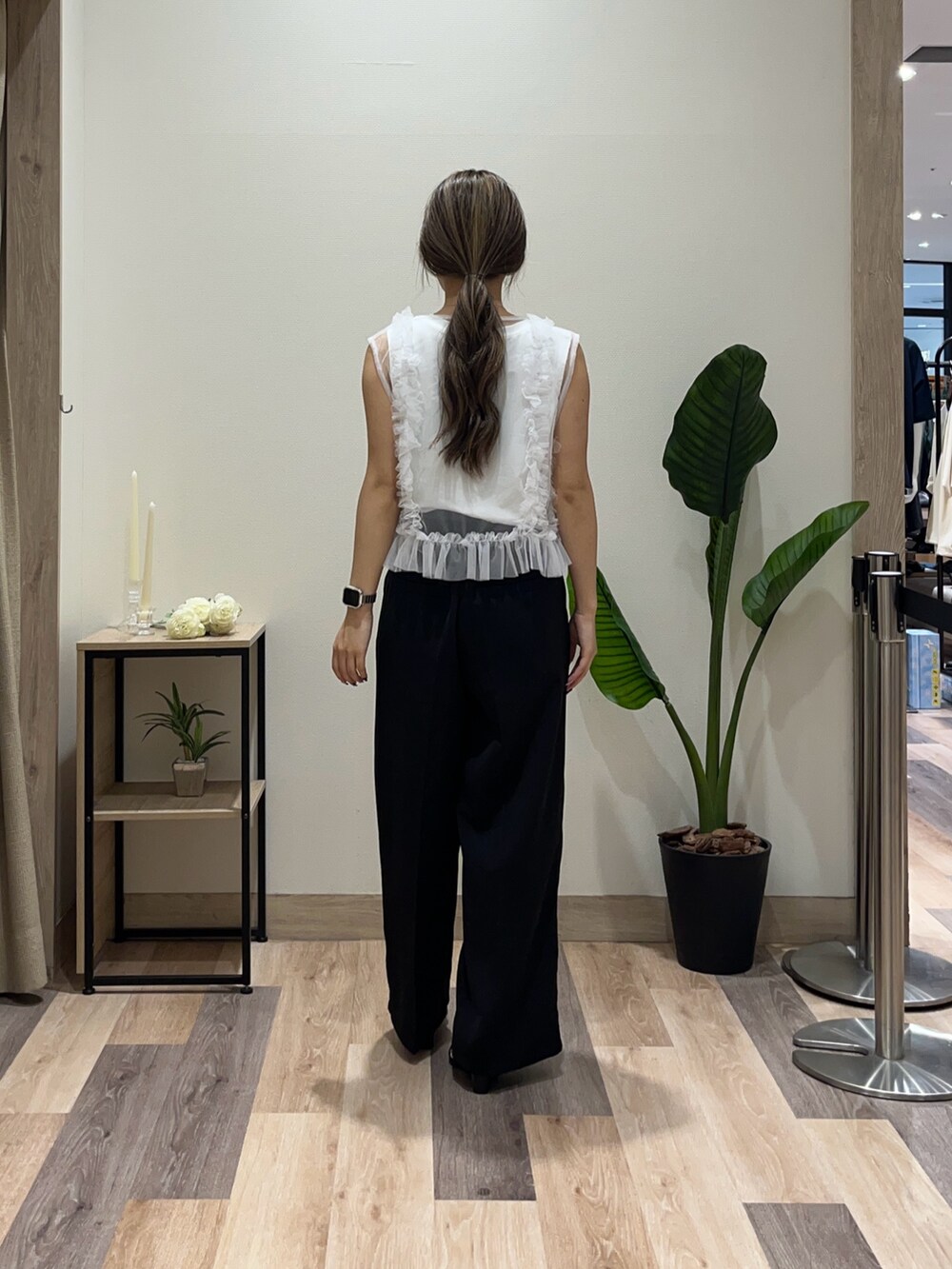 ブラック系のスラックス、ホワイト系のTシャツ/カットソー、ブラック系のベルトを着用したレディースの夏コーディネートの3枚目の写真