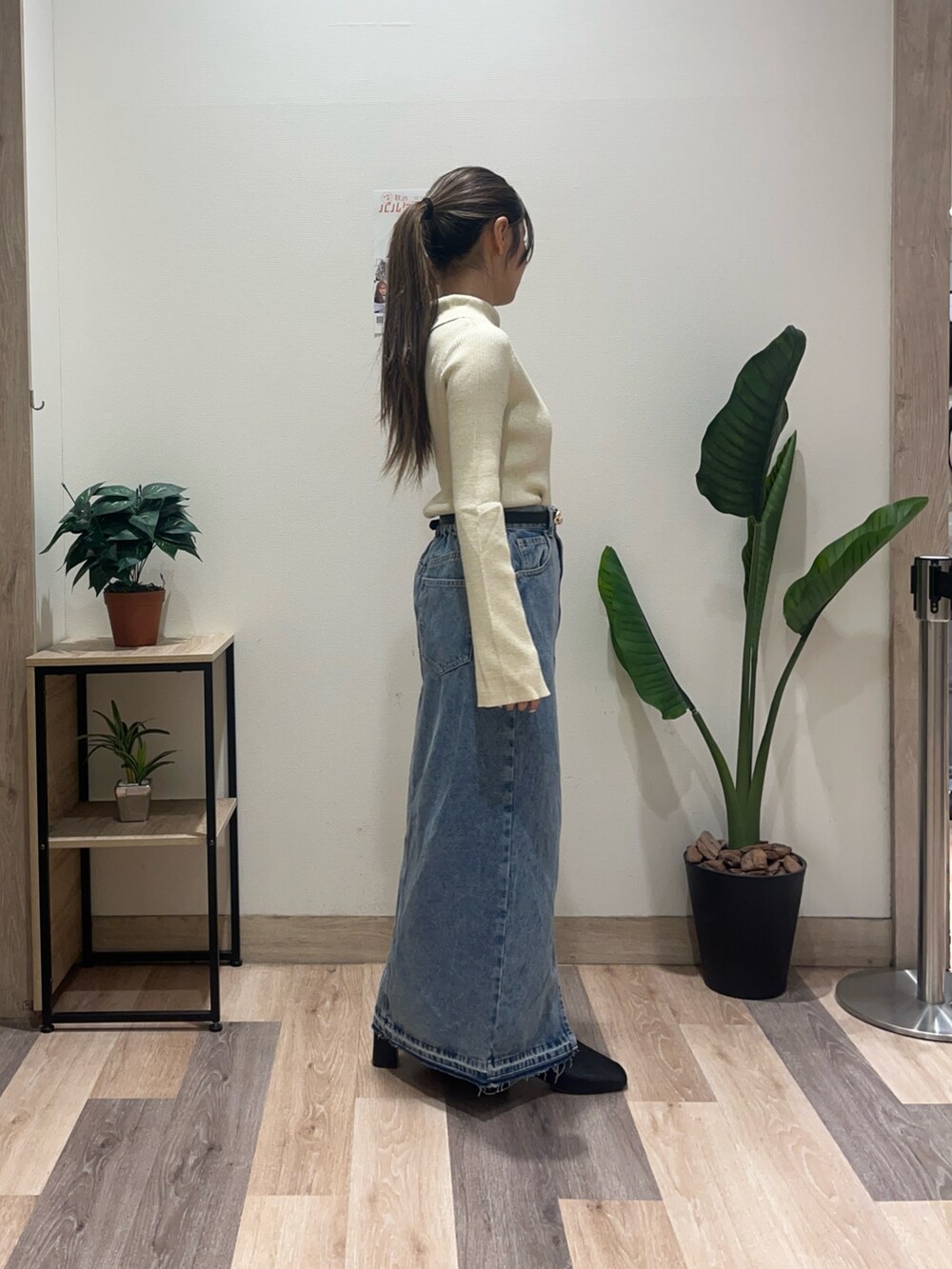 ブルー系のスカート、ホワイト系のニット/セーター、ブラック系のベルトを着用したレディースの秋コーディネートの3枚目の写真