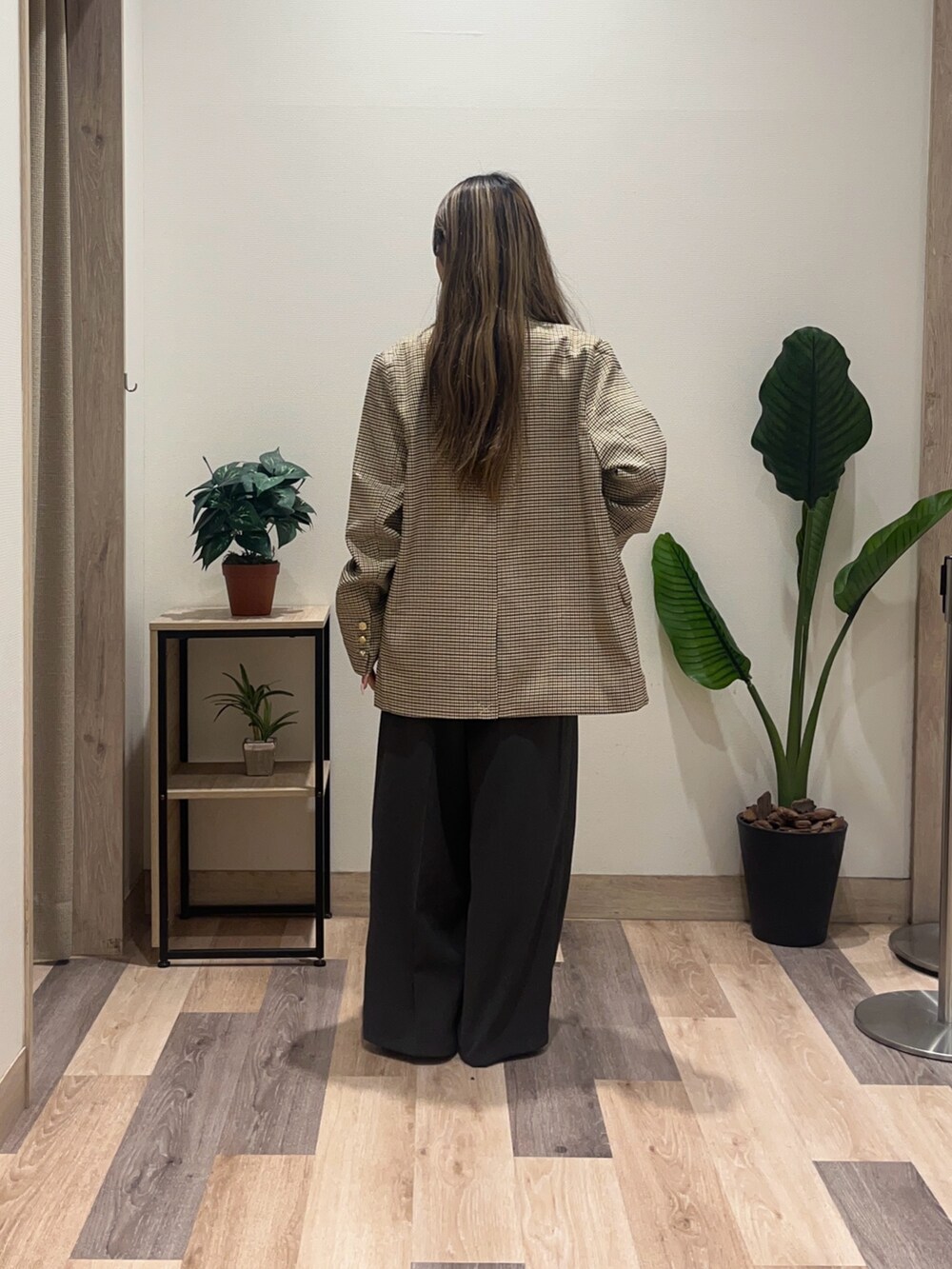 グレー系のスラックス、ベージュ系のテーラードジャケット、ブラック系のベルトを着用したレディースの秋コーディネートの3枚目の写真