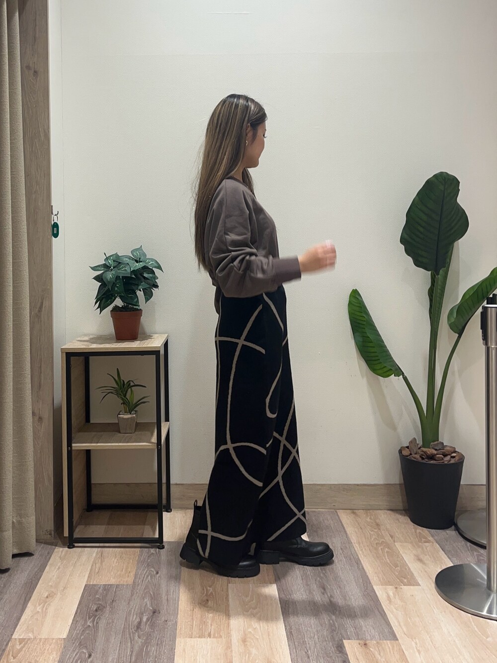 ブラック系のスカート、ブラウン系のTシャツ/カットソー、ブラック系のブーツを着用したレディースの秋コーディネートの3枚目の写真