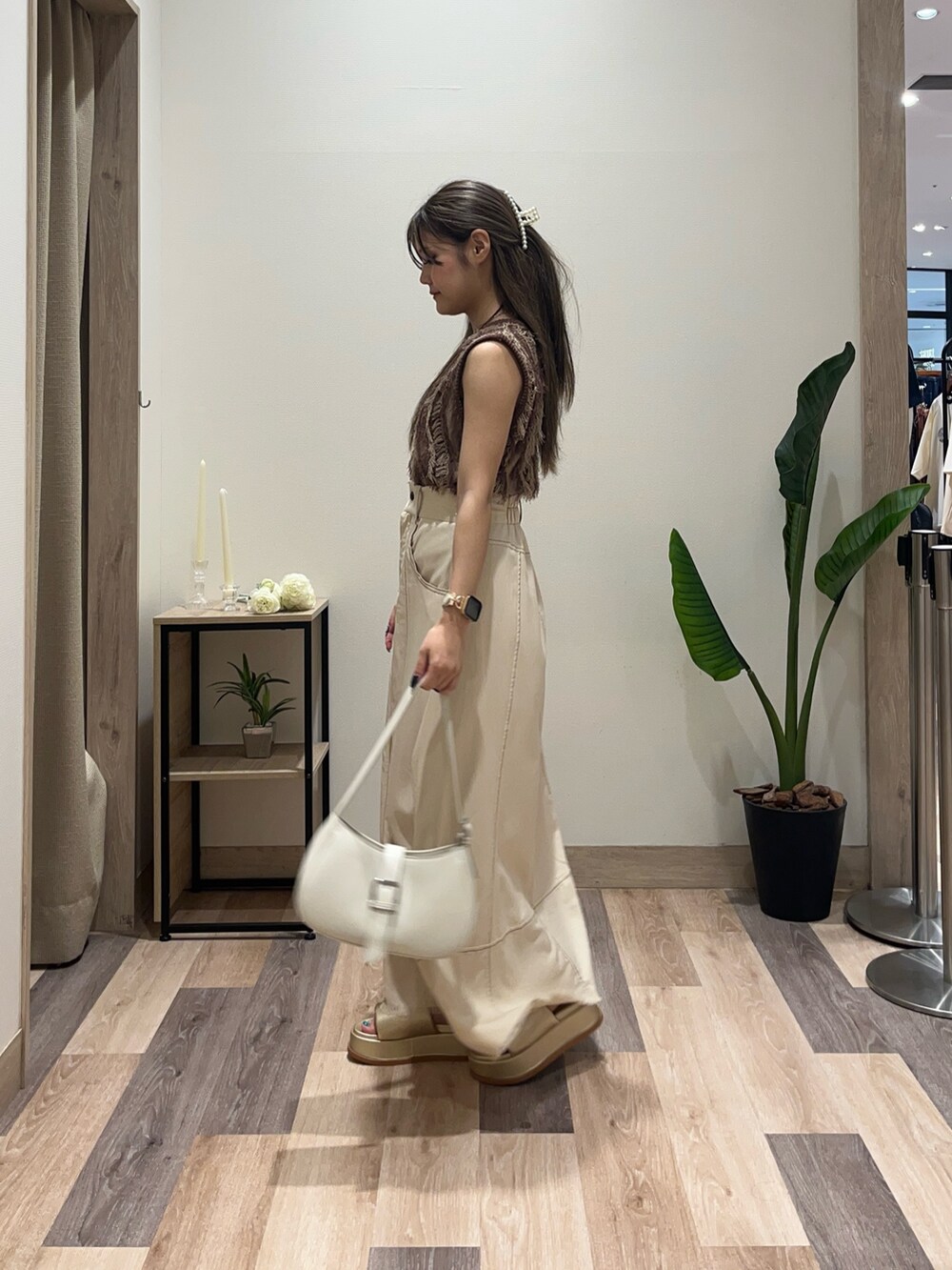 ブラウン系のニット/セーター、ベージュ系のスカート、ホワイト系のボストンバッグを着用したレディースの夏コーディネートの4枚目の写真