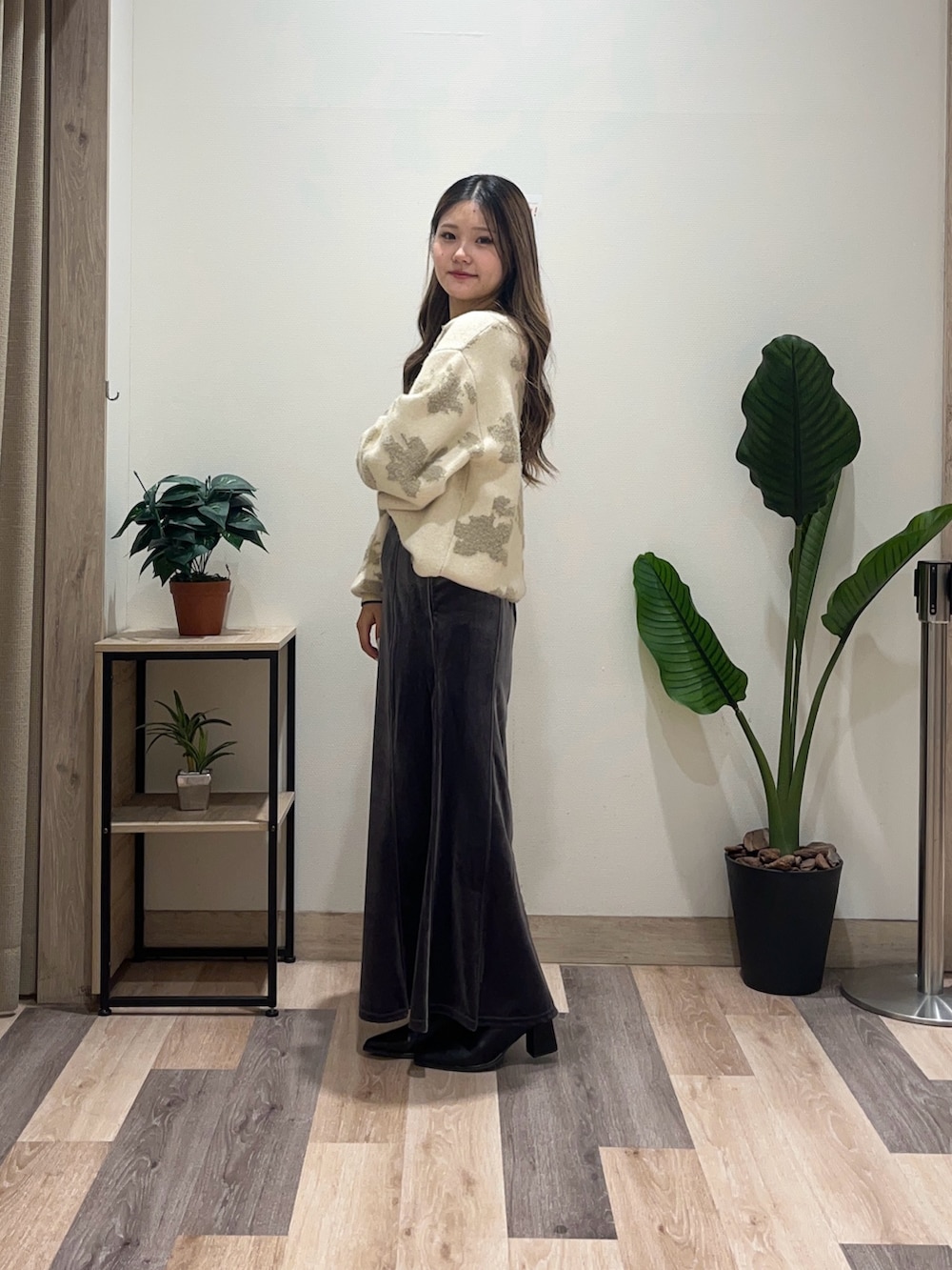 グレー系のスカート、ホワイト系のニット/セーター、ブラック系のブーツを着用したレディースの秋コーディネートの5枚目の写真