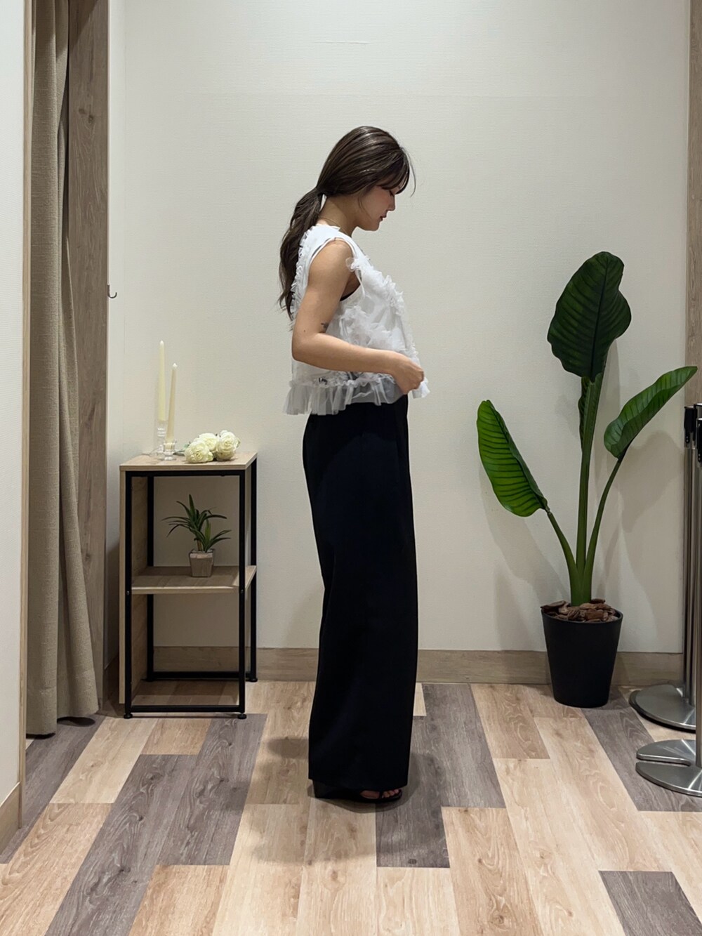 ブラック系のスラックス、ホワイト系のTシャツ/カットソー、ブラック系のベルトを着用したレディースの夏コーディネートの2枚目の写真