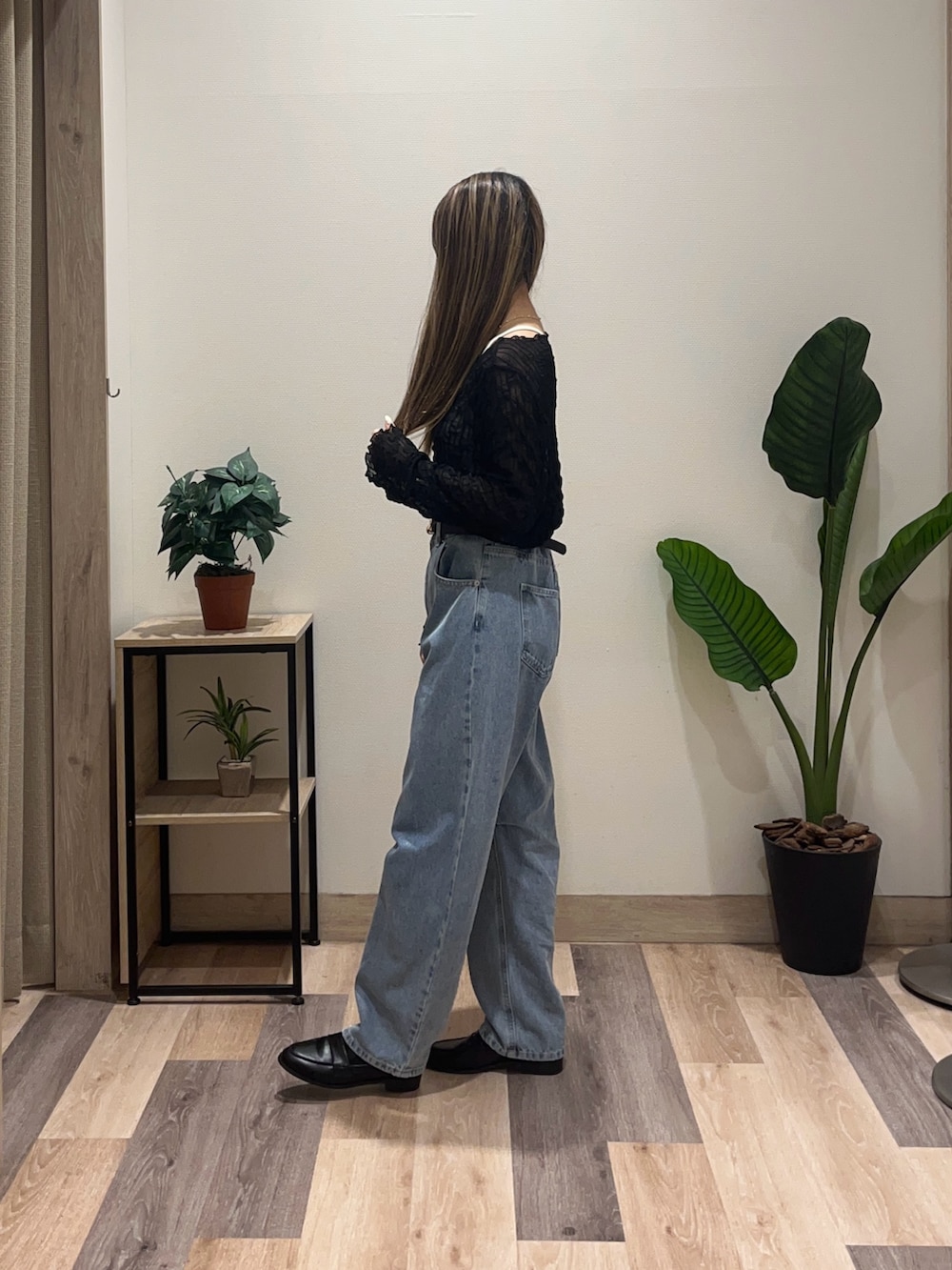 ブルー系のデニムパンツ、ブラック系のTシャツ/カットソー、ブラック系のベルトを着用したレディースの秋コーディネートの5枚目の写真