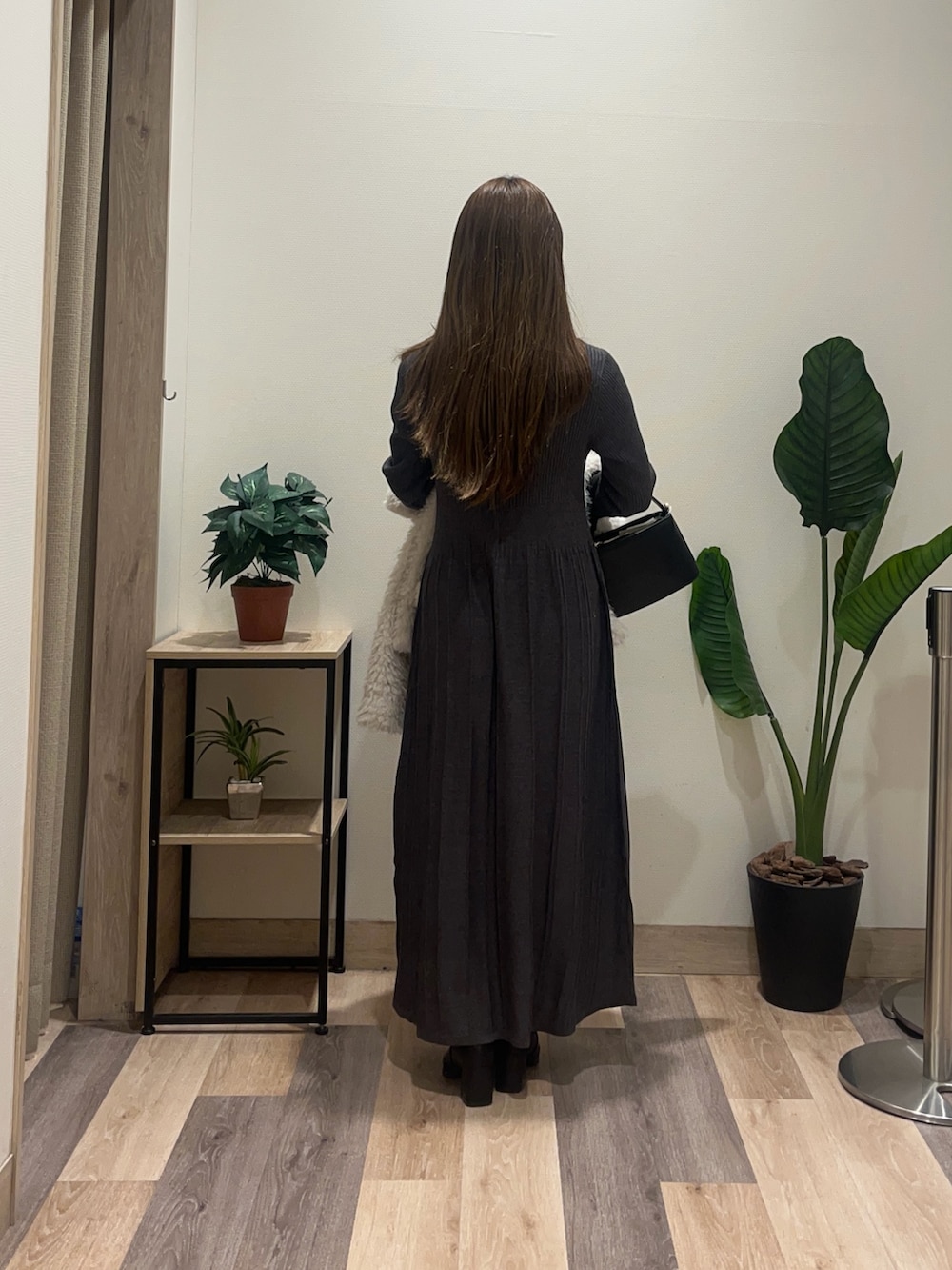 グレー系のワンピース、ホワイト系のブルゾン、ブラック系のブーツを着用したレディースの冬コーディネートの4枚目の写真