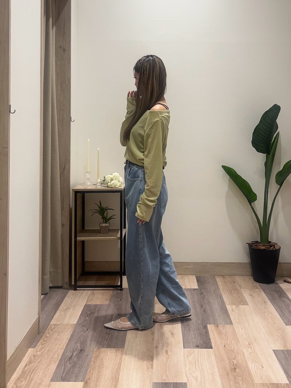 ブルー系のデニムパンツ、ホワイト系のサンダル、グリーン系のTシャツ/カットソーを着用したレディースの秋コーディネートの4枚目の写真