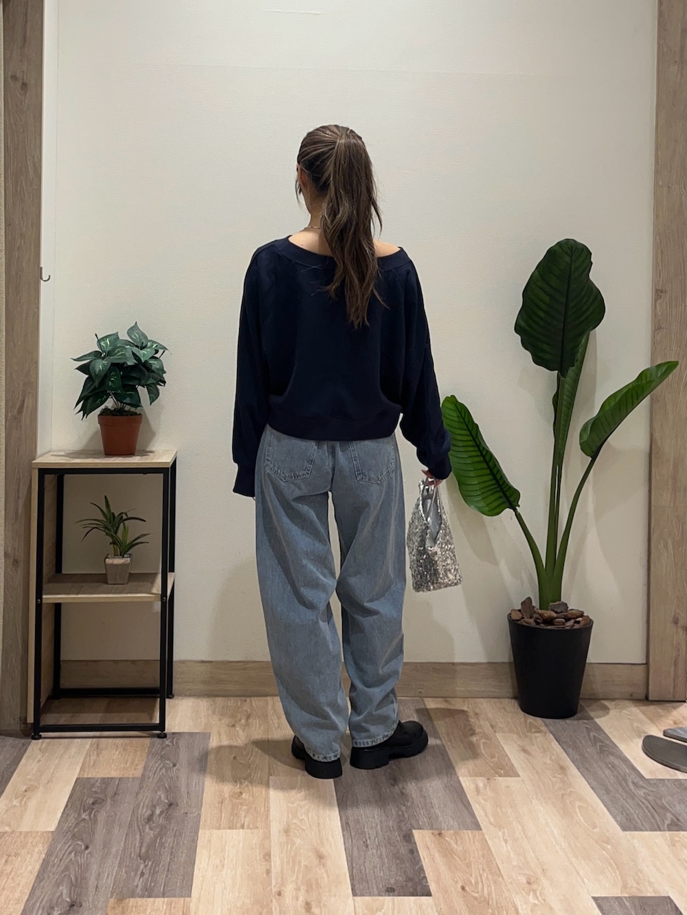 ブルー系のデニムパンツ、ブルー系のTシャツ/カットソー、ブラック系のブーツを着用したレディースの秋コーディネートの4枚目の写真