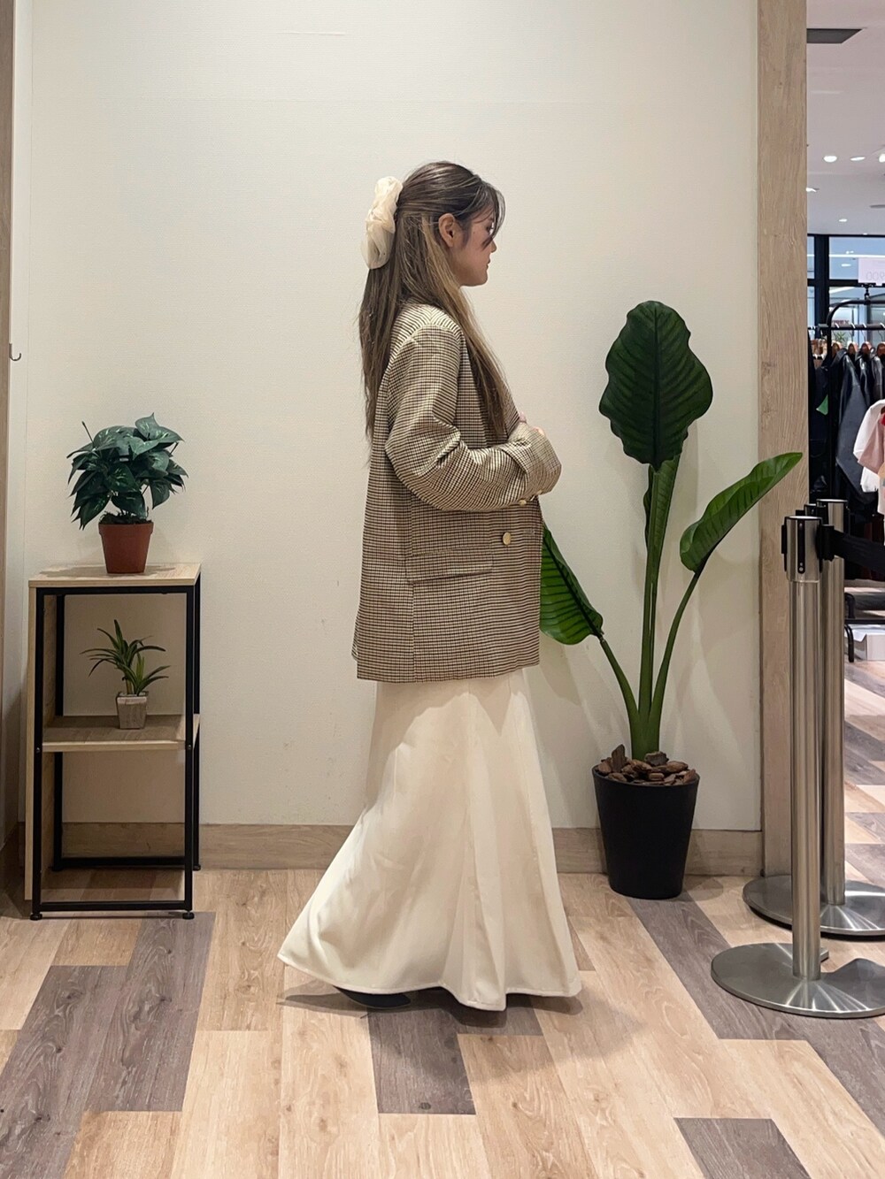 ホワイト系のスカート、ベージュ系のテーラードジャケット、ブラウン系のTシャツ/カットソーを着用したレディースの秋コーディネートの3枚目の写真