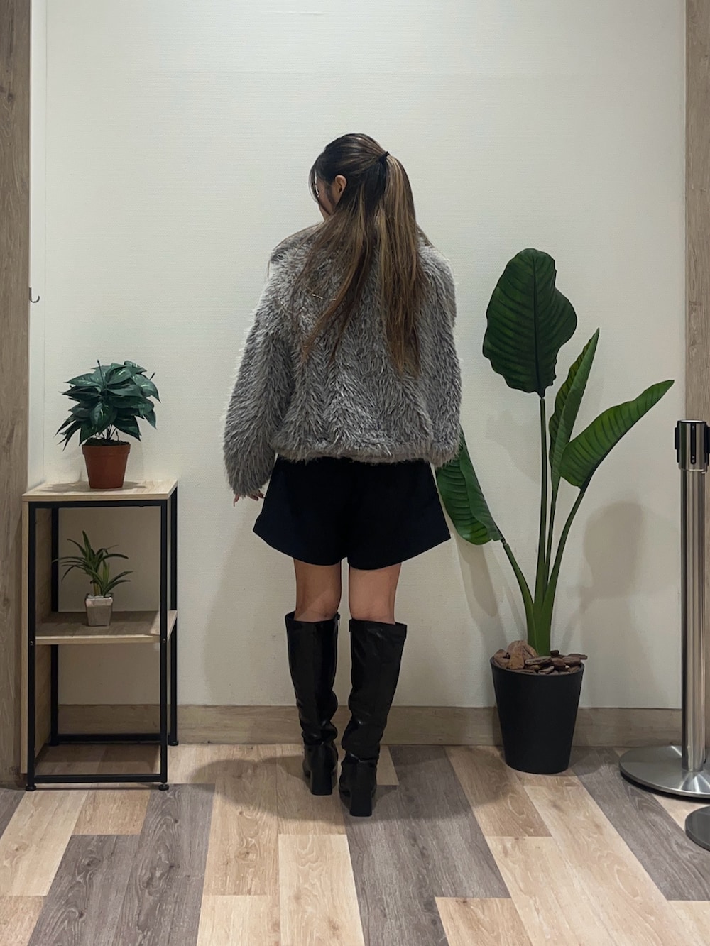 ホワイト系のニット/セーター、グレー系のブルゾン、ブラック系のブーツを着用したレディースの秋コーディネートの4枚目の写真