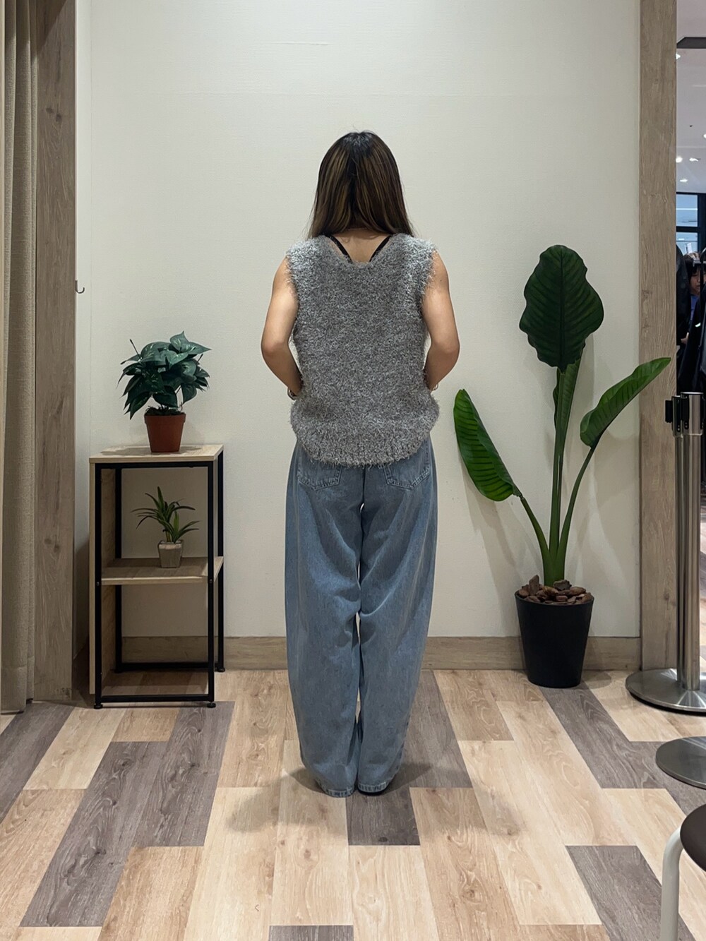 ブルー系のデニムパンツ、ブラック系のパンプス、グレー系のニット/セーターを着用したレディースの秋コーディネートの4枚目の写真