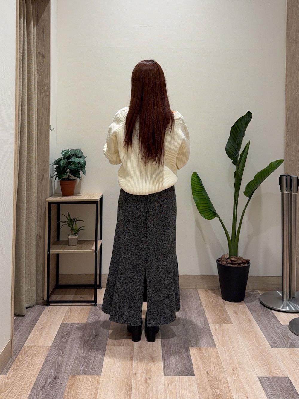 ホワイト系のニット/セーター、ブラック系のスカート、ブラック系のブーツを着用したレディースの冬コーディネートの3枚目の写真