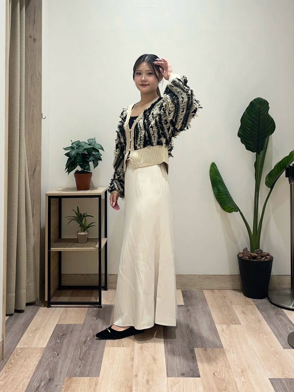 ホワイト系のスカート、ブラック系のパンプス、ブラック系のカーディガン/ボレロを着用したレディースの秋コーディネートの4枚目の写真