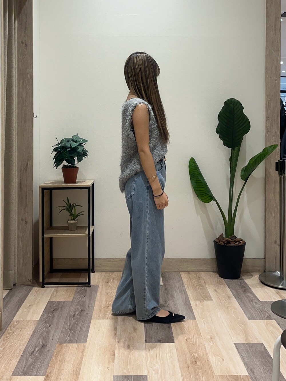 ブルー系のデニムパンツ、ブラック系のパンプス、グレー系のニット/セーターを着用したレディースの秋コーディネートの3枚目の写真