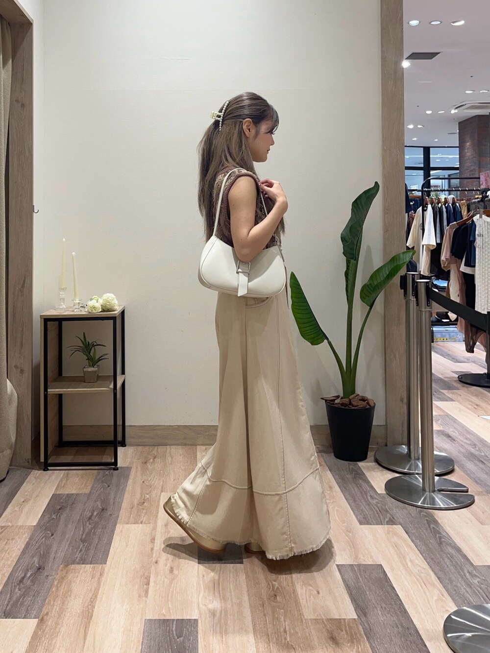 ブラウン系のニット/セーター、ベージュ系のスカート、ホワイト系のボストンバッグを着用したレディースの夏コーディネートの2枚目の写真