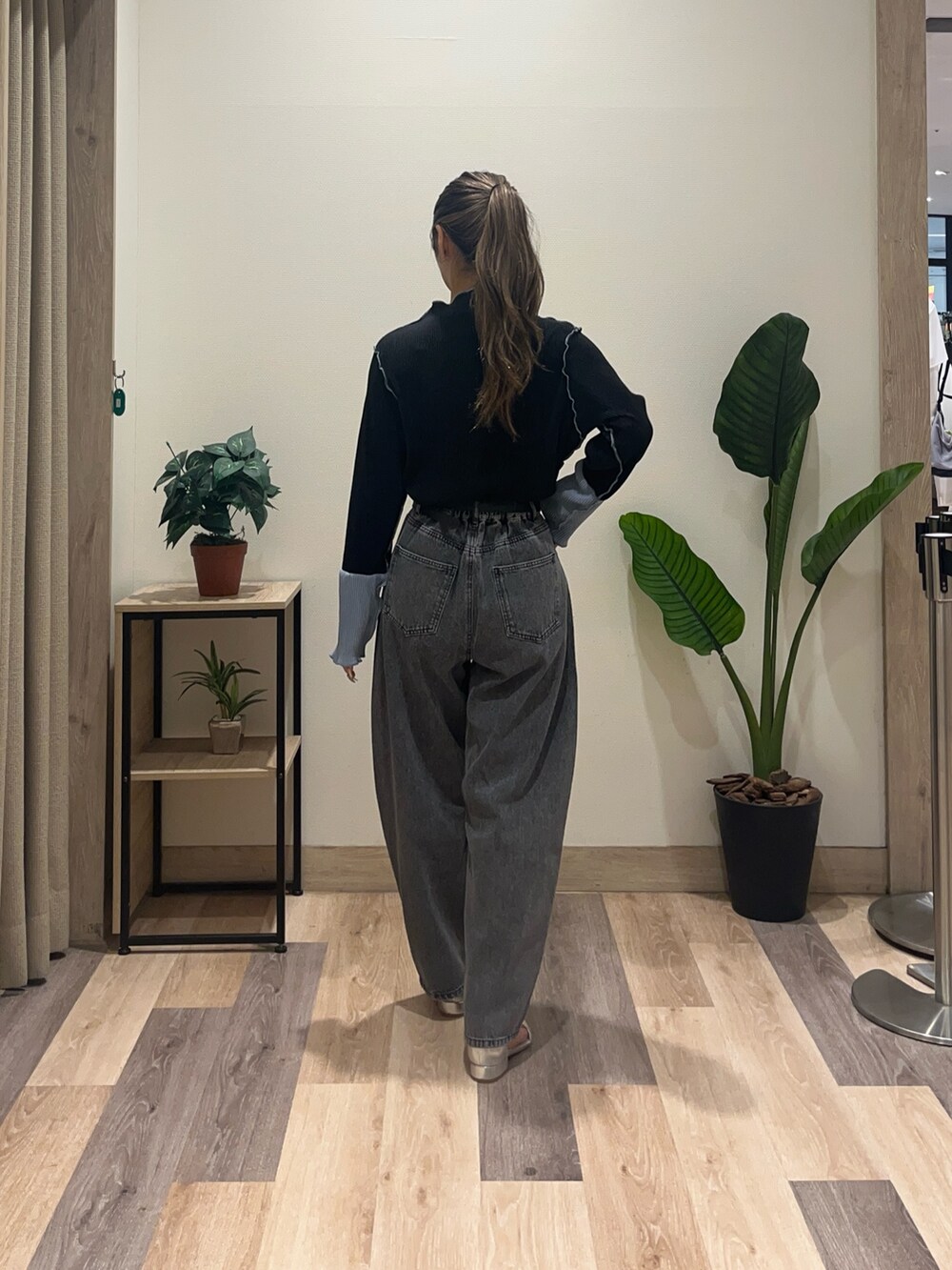 ブラック系のデニムパンツ、ブラック系のTシャツ/カットソー、ブラック系のベルトを着用したレディースの秋コーディネートの4枚目の写真