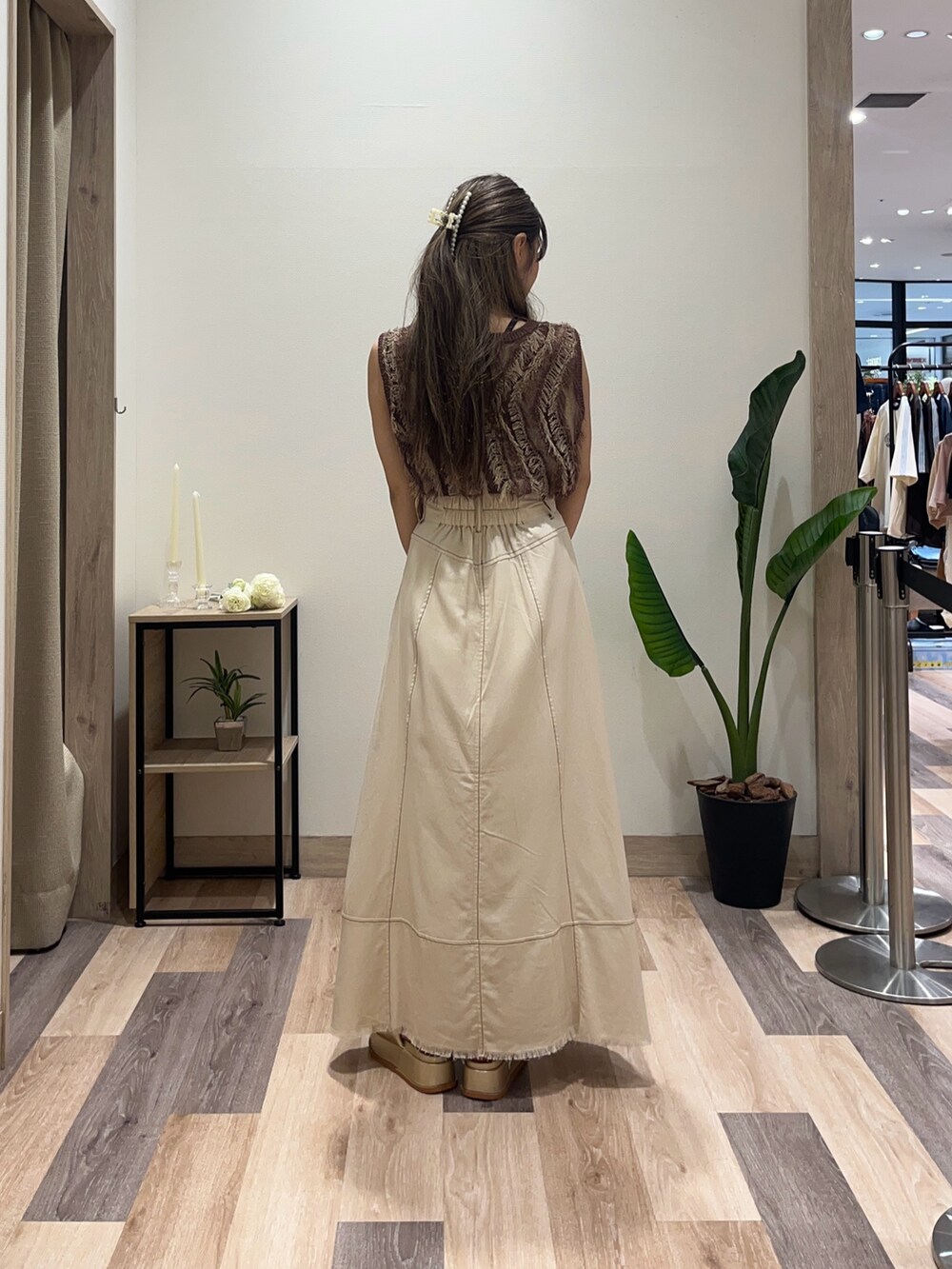 ブラウン系のニット/セーター、ベージュ系のスカート、ホワイト系のボストンバッグを着用したレディースの夏コーディネートの3枚目の写真