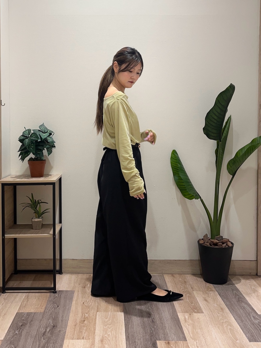 グリーン系のTシャツ/カットソー、ブラック系のスラックス、ブラック系のパンプスを着用したレディースの秋コーディネートの3枚目の写真
