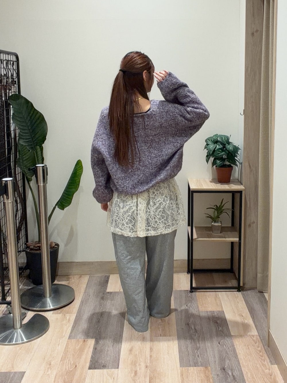 パープル系のニット/セーター、ホワイト系のチュニック、グレー系のその他パンツを着用したレディースの冬コーディネートの3枚目の写真