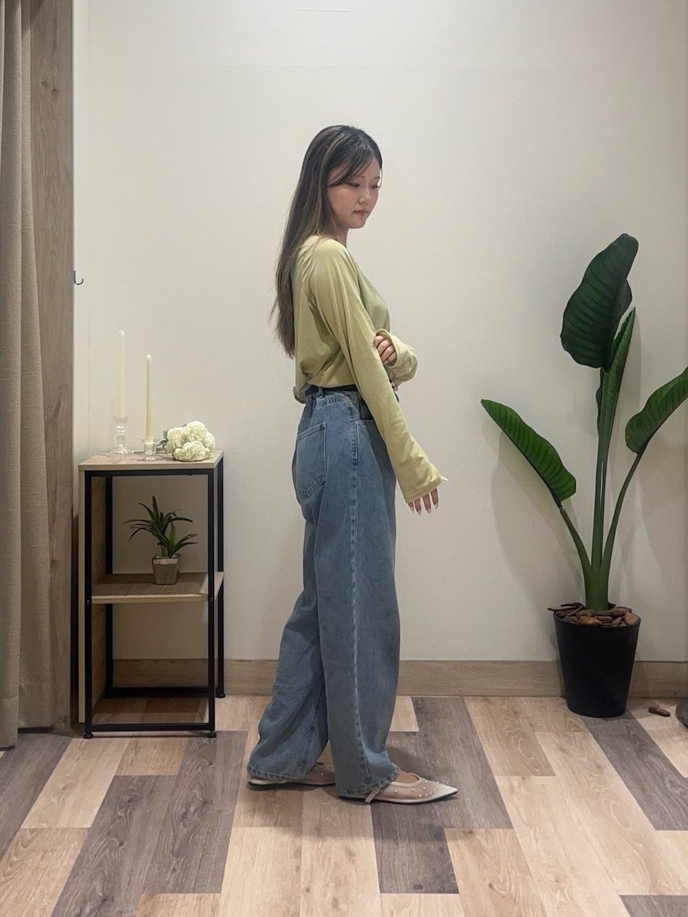 ブルー系のデニムパンツ、ホワイト系のサンダル、グリーン系のTシャツ/カットソーを着用したレディースの秋コーディネートの2枚目の写真