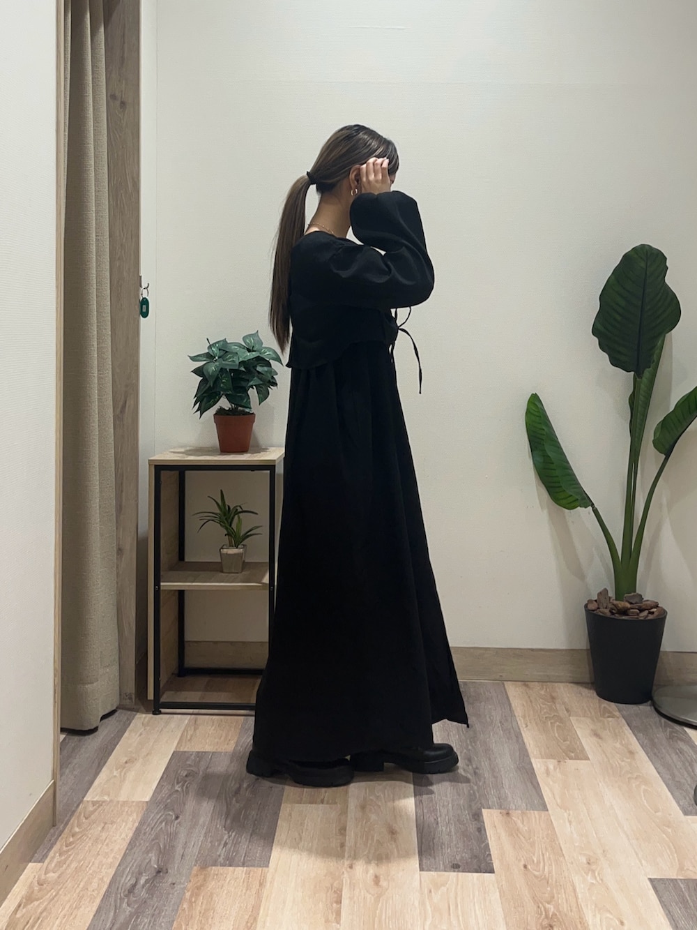 ブラック系のワンピース、ブラック系のブーツを着用したレディースの秋コーディネートの3枚目の写真