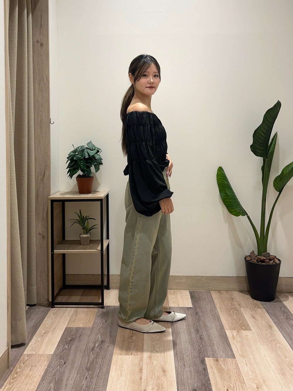 ホワイト系のパンプス、ブルー系のデニムパンツ、ブラック系のシャツ/ブラウスを着用したレディースの秋コーディネートの3枚目の写真