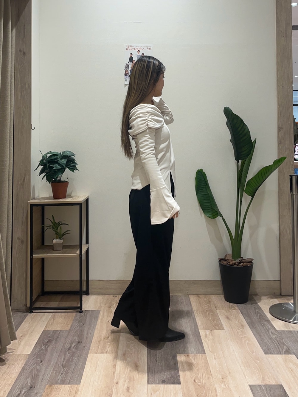 ブラック系のスラックス、ホワイト系のTシャツ/カットソー、ブラック系のブーツを着用したレディースの秋コーディネートの3枚目の写真