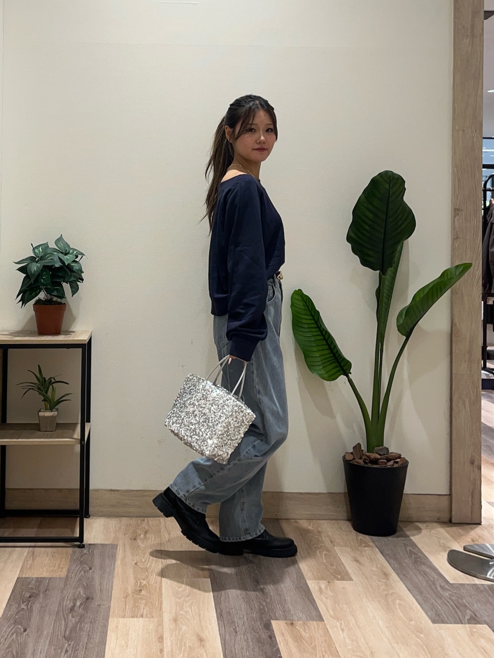 ブルー系のデニムパンツ、ブルー系のTシャツ/カットソー、ブラック系のブーツを着用したレディースの秋コーディネートの3枚目の写真