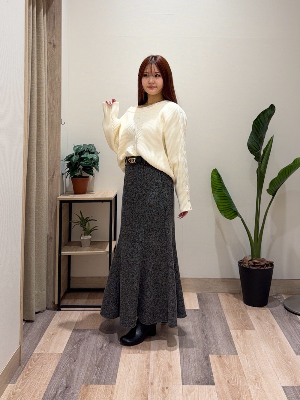 ホワイト系のニット/セーター、ブラック系のスカート、ブラック系のブーツを着用したレディースの冬コーディネートの4枚目の写真