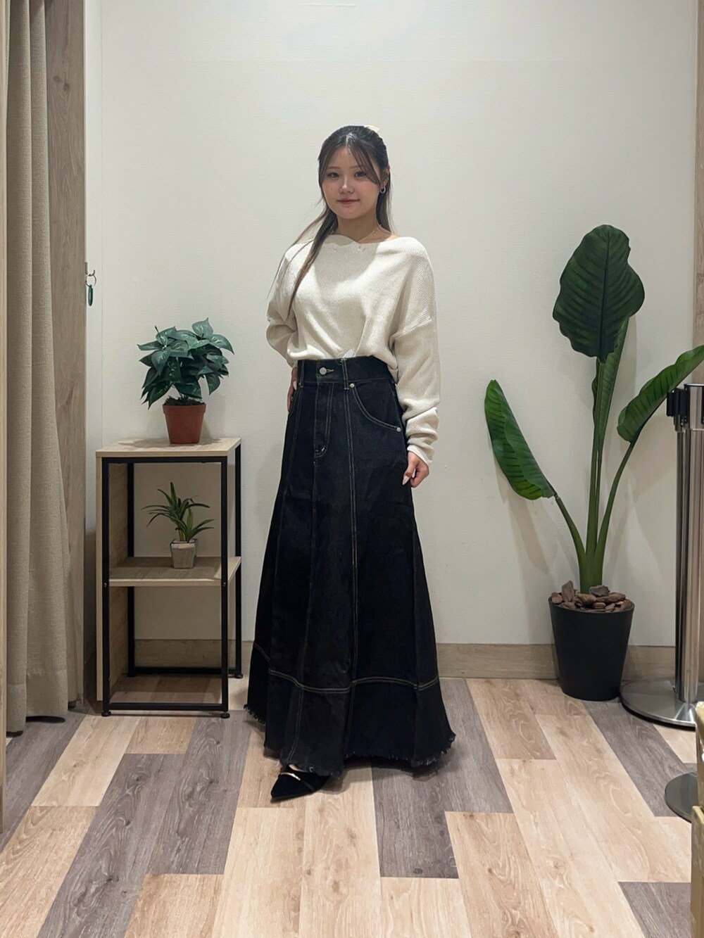 ブラック系のスカート、ブラック系のパンプス、ホワイト系のニット/セーターを着用したレディースの秋コーディネートの4枚目の写真