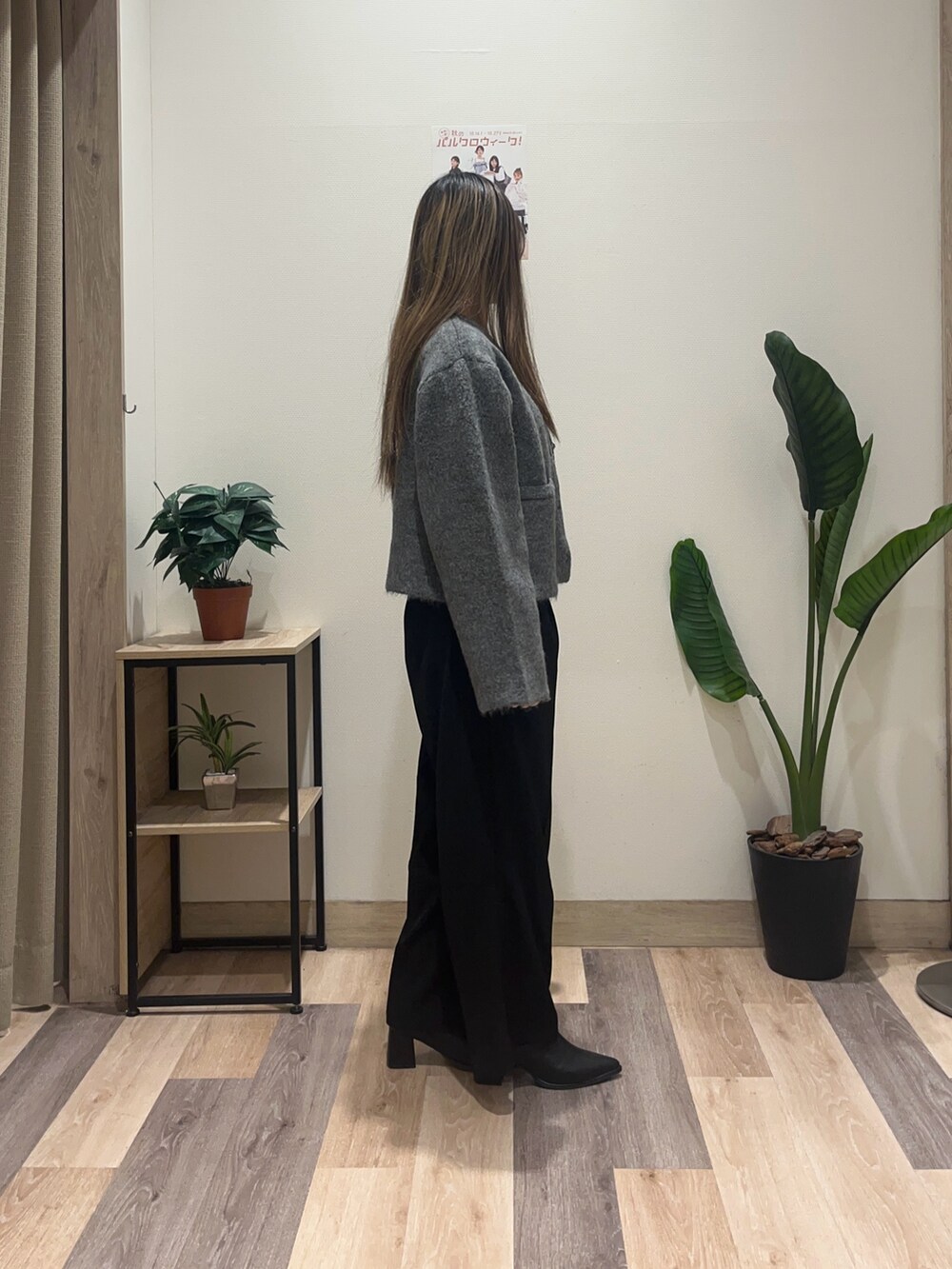 ブラック系のスラックス、グレー系のブルゾン、ホワイト系のニット/セーターを着用したレディースの秋コーディネートの3枚目の写真