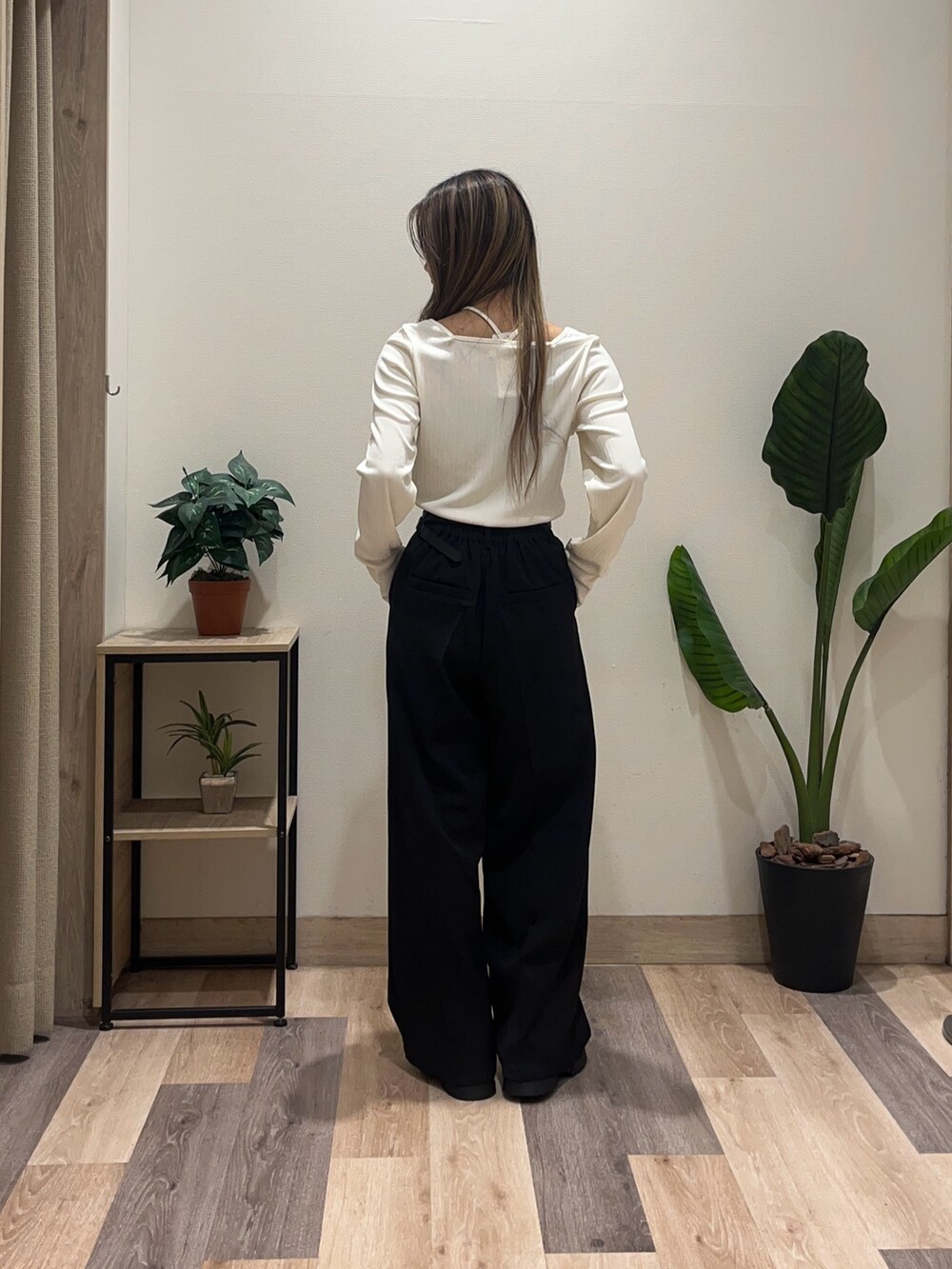 ホワイト系のTシャツ/カットソー、ブラック系のスラックス、ブラック系のブーツを着用したレディースの秋コーディネートの3枚目の写真