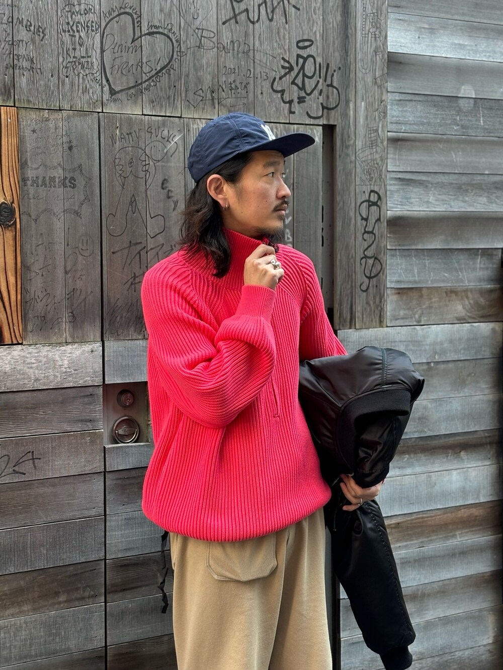 ピンク系のニット/セーター、ブラック系のジャケット/アウターを着用したメンズの秋コーディネートの2枚目の写真